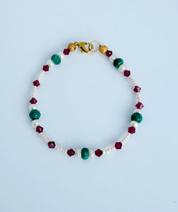 Malachite gemstone and freshwater pearl bracelet with crystal accents and gold plated closure.