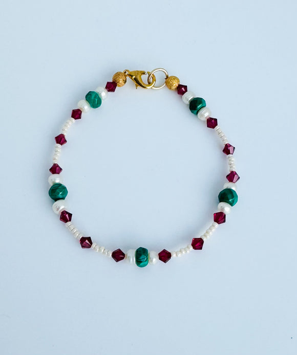 Malachite gemstone and freshwater pearl bracelet with crystal accents and gold plated closure.